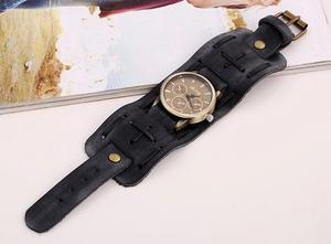Macro view of vintage punk wide black leather strap with cross stitching and bronze rivets