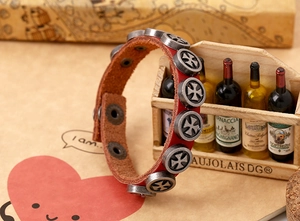 Detail of red leather punk bracelet with silver cross rivets and adjustable snap buttons