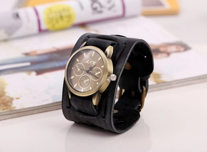 Macro shot of vintage bronze watch face with black leather punk bracelet and rivets