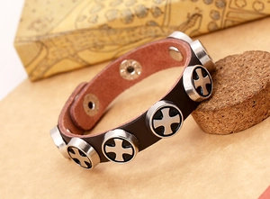 Detail of dark brown leather bracelet with silver cross rivets and snap closure