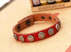 Macro shot of red leather punk bracelet with silver star studs and snap fasteners