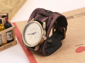 Macro detail of retro wide leather band with studs and bronze finish quartz watch dial