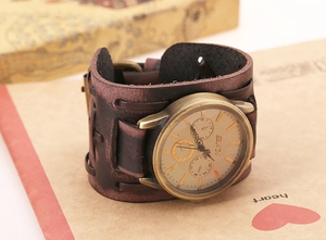 Detail of vintage bronze watch dial with rustic brown wide leather braided strap