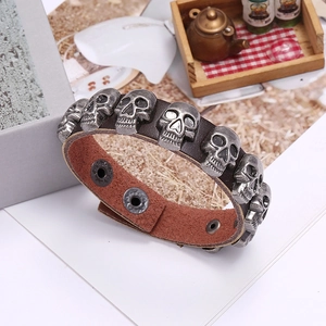 Detail of dark brown leather punk bracelet with silver skull rivets and snap buttons
