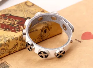 Detail of white leather bracelet with cross-embossed metal studs and button snap