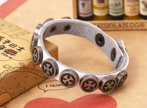 Detail of white punk leather bracelet featuring silver cross studs and snap button closure