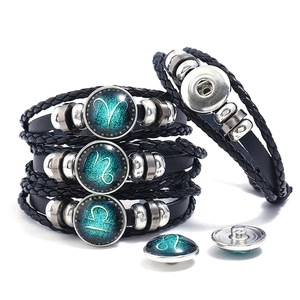 Close-up of woven leather zodiac bracelets with interchangeable snap buttons and galaxy glass
