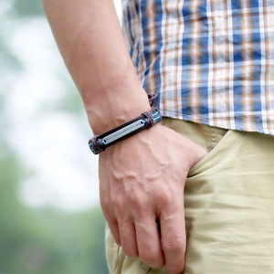 Handmade woven brown leather bracelet for men featuring an engraved inspirational metal plate