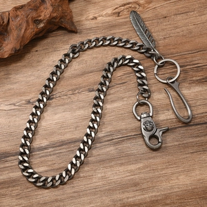 Retro punk wallet chain with silver finish feathers and skulls on wooden surface