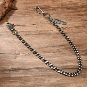 Detail of vintage silver wallet chain featuring chunky links and carved feather pendant