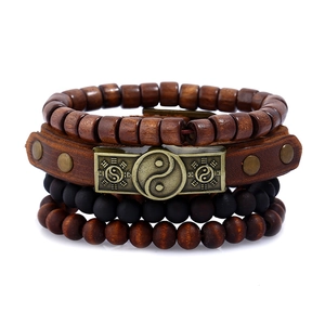 Close-up of multilayer leather bracelet with wooden beads and bronze Yin Yang charm