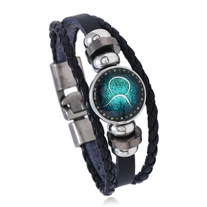 Macro shot of Taurus constellation glass dome on multi-layer braided leather bracelet