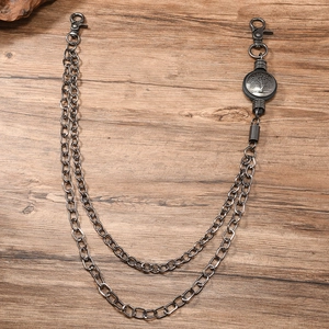 Detail of double-layer metal pants chain with tree of life charm on wood surface