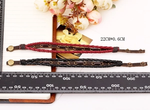 Detail view of woven leather bracelets in red and black with vintage metal eyelets
