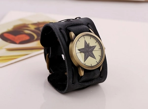 Detail of vintage wide black leather strap with rivets and bronze star dial watch