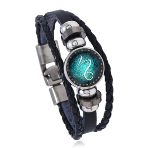 Macro view of multi-layer braided leather bracelet with Capricorn zodiac glass cabochon