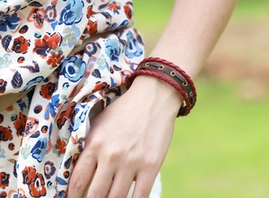 Close-up of multilayer braided leather bracelet with vintage metal eyelets on wrist