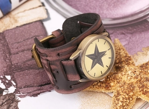 Detail showing vintage brown leather watch strap with bronze case and star pattern dial
