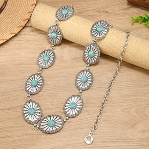 Bohemian silver metal waist chain with turquoise stones on a natural wooden background