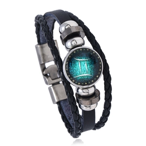 Detail of multi-layer leather bracelet with Gemini zodiac sign glass dome and metallic beads