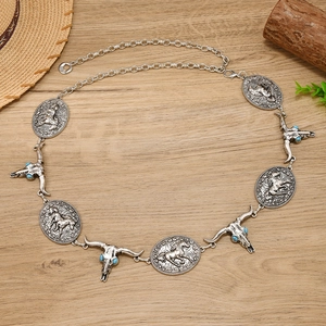 Detail of vintage silver metal waist chain with western bull skull and horse charms