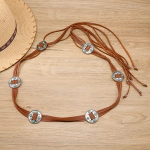 Détail d'une ceinture bohème en cuir tressé avec conchos turquoise et longs glands