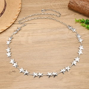 Détail de la ceinture chaîne à étoiles argentées avec fermoir mousqueton sur bois