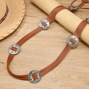 Détail d'une ceinture en cuir PU marron bohème avec des conchos argentés et des perles bleues