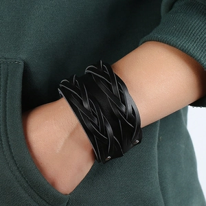 Dettaglio del bracciale in pelle nera intrecciata multistrato in stile punk sul polso di un uomo