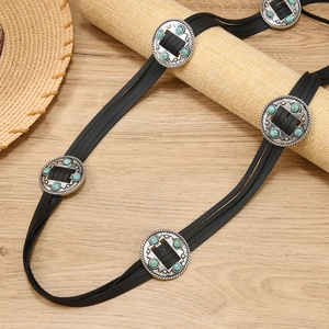 Détail d'une ceinture en cuir de style western avec boucles argentées et perles turquoise