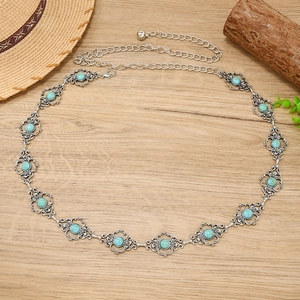 Détail de la chaîne de taille bohème en métal argenté avec gravure florale turquoise
