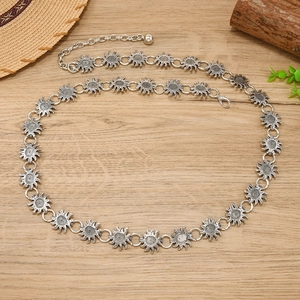 Detail of vintage silver sunflower metal waist chain with lobster clasp on wood