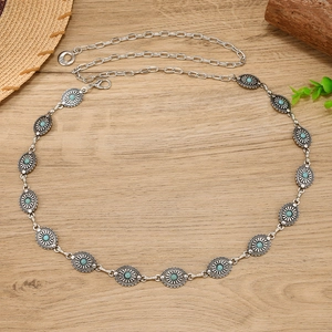 Detail of vintage silver metal belt with turquoise stones and floral oval links