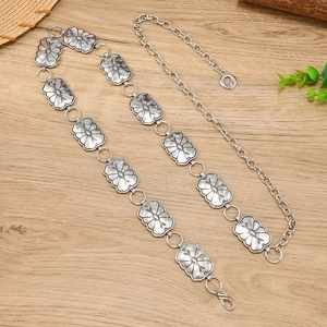 Bohemian silver metal waist chain with engraved geometric patterns on wood background
