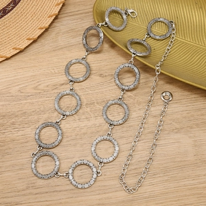 Bohemian style silver hollow circle waist chain with engraved texture on wooden background