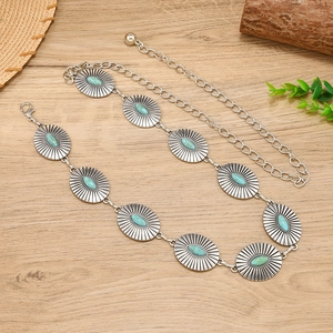 Bohemian silver metal waist chain with turquoise stones on vintage wood background