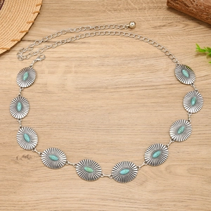 Detail of bohemian metal waist chain with turquoise stones and sunburst engravings