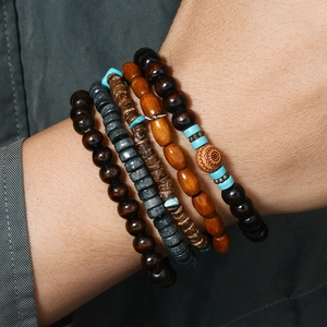 Dettaglio di bracciali bohémien in legno a strati con totem solare e accenti turchesi