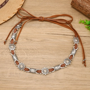 Detail of bohemian brown suede belt with vintage silver sunburst metal carvings