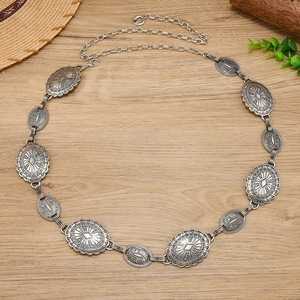 Detail of vintage antique silver metal waist chain with embossed bohemian medallions