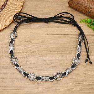 Detail of bohemian black leather waist chain with vintage silver floral metal ornaments