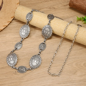 Bohemian vintage silver metal waist chain with sun pattern on wooden background