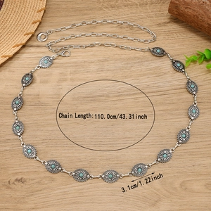Bohemian silver chain belt with turquoise oval plates and floral engraving on wood background