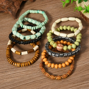 Detail of colorful multilayered bohemian stretch beaded bracelets on a natural wood surface