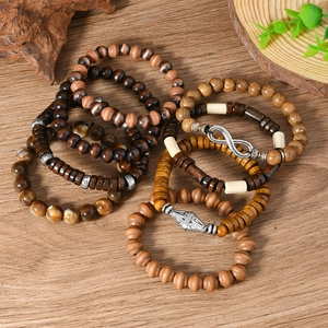 Detail of 8-piece vintage wooden bead and stone bracelets set on a natural wood surface
