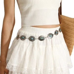 Bohemian silver metal concho waist chain with turquoise stones on a white summer dress