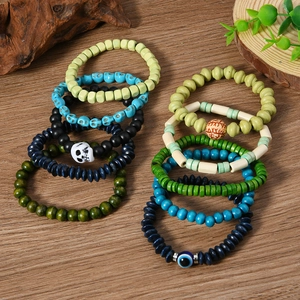 Detail of 10 bohemian beaded bracelets with skull charms and evil eye on wooden background
