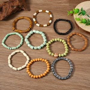 Detail shot of 10 bohemian stretch bead bracelets in earthy tones on wooden background