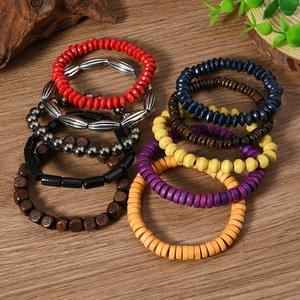 Detail of bohemian wood bead bracelets set with various colors and textures