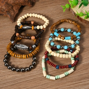 Detail of bohemian beaded bracelet set featuring wooden and turquoise beads on wood texture